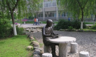 坐石桌凳看书的学生铜雕