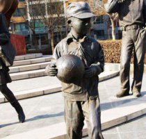 拿足球的小学生人物铜雕