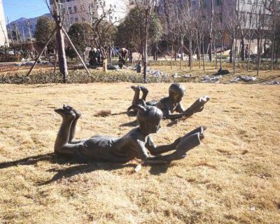 公园人物趴着看书的儿童玻璃钢仿铜雕塑