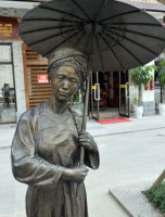 步行街打伞的少数民族女人人物铜雕