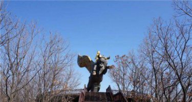 公园站在飞牛上的小男孩景观铜雕