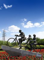 骑三人自行车的一家三口铜雕 