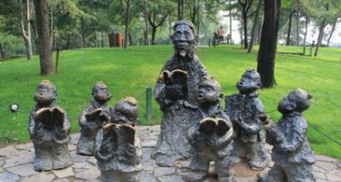 公园读书的儿童人物铜雕